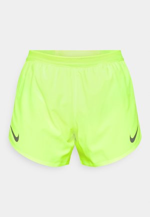 Shorts deportivos de color amarillo neón fabricados con material ligero, cuentan con una cintura de malla y un logo negro de Nike en la pierna izquierda.