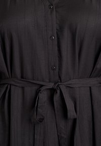 Czarna sukienka zapinana na guziki, wykonana z teksturowanej tkaniny, z paskiem w talii i luźnym fasonem z subtelnymi pionowymi liniami.