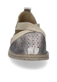 Metaliczne srebrne buty z perforowanym wzorem, beżowe tekstylne paski z przodu, płaska podeszwa i fakturowana cholewka.