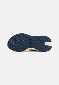 Navy rubber sneaker outsole features a textured surface with square and diamond patterns, embossed "NIKE" logo, and a white accent shape.