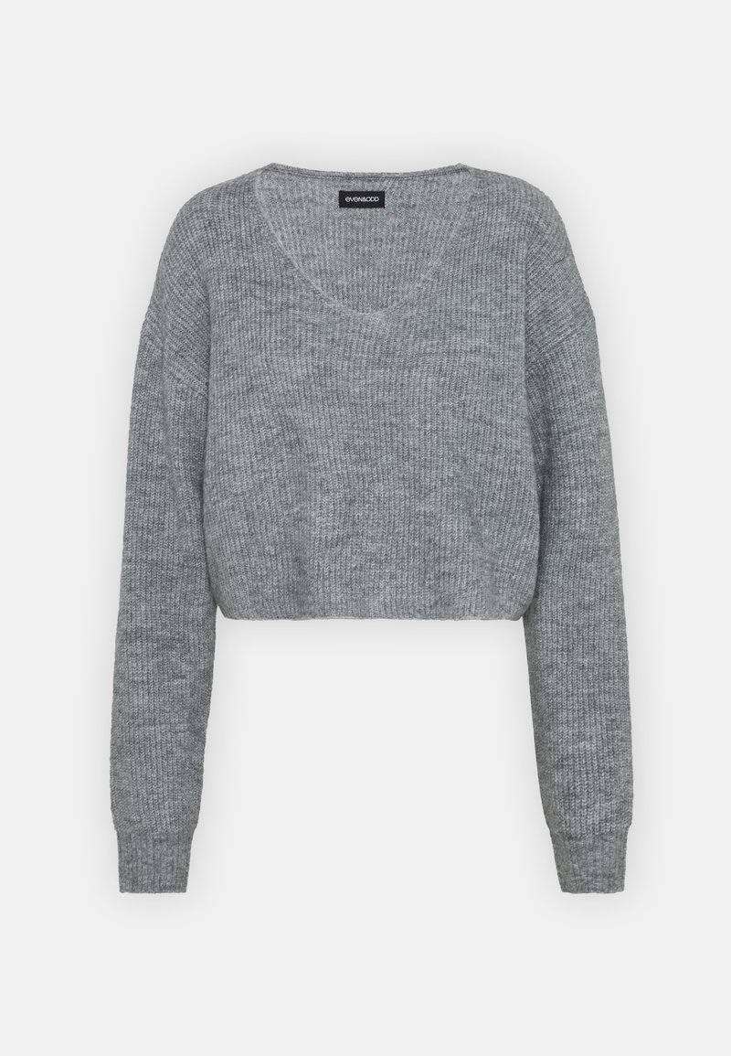 Pull court gris en maille avec manches longues et encolure ronde, présentant une texture côtelée.