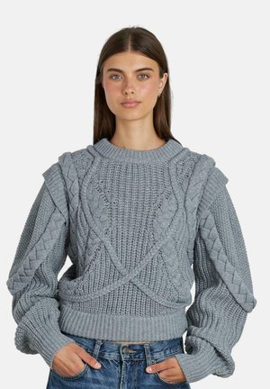 Sudadera gris de punto con patrones de cable texturizados, hombros caídos y puños acanalados. Tejido ligero con un corte relajado.