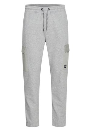 Lys grå joggebukser laget av myk stoff. Har snor i livet og to store sidelommer med kontrasterende grønn detalj.