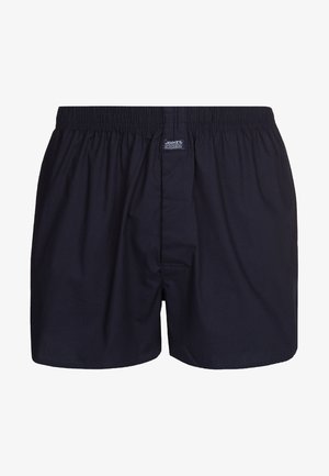 Marineblaue Boxershorts aus weichem Stoff, mit einem elastischen Bund, einer Frontöffnung und einem kleinen Logo-Tag am Bund.