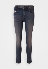 Mörkblå smala jeans i denim med en blekt yta, en framficka och en liten slits på vänster knä. Traditionell design med fem fickor.