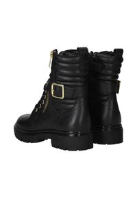 Zwarte leren enkelboots met ribbel detail, gouden hardware accenten, een vetersluiting aan de voorkant en een robuuste zool. Ritssluiting aan de zijkant voor eenvoudig aan- en uittrekken.