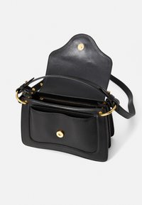 Borsa a mano in pelle nera con design strutturato, accessori in oro e più scomparti. Presenta una texture liscia e una chiusura magnetica.