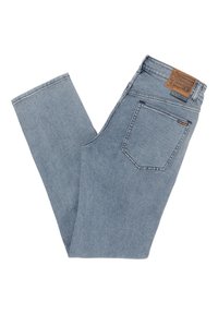 Jean en denim bleu clair plié, montrant la poche arrière avec le logo Volcom et une patch de marque en cuir marron sur la taille.