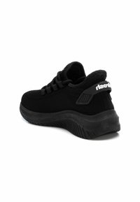 Zapato deportivo negro con parte superior de punto, puntera redondeada, suela de goma gruesa y acentos texturizados. Presenta un talón reforzado y detalle de logo.