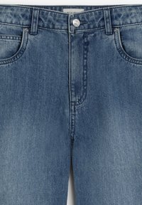 Jeans de mezclilla azul con un acabado desvanecido, cinco bolsillos, pasadores para cinturón y un cierre de botón plateado en la cintura. La superficie es suave con ligera textura.