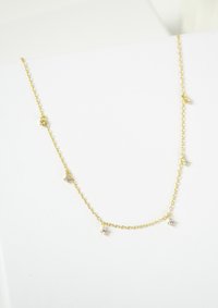 Collana in oro con piccoli gemme trasparenti disposti lungo la catena, dal design delicato e dalla superficie liscia.