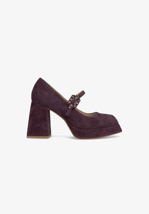 Purple suede high heel shoe with a chunky block heel, rounded toe, and decorative buckle strap detail on the front.