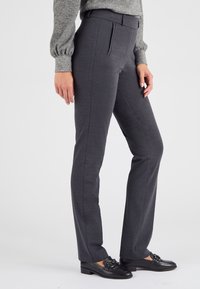 Grijze op maat gemaakte broeken met een slim fit, met een gladde textuur, zijplooien aan de voorkant en een middelhoge tailleband. Gepaard met zwarte instappers.