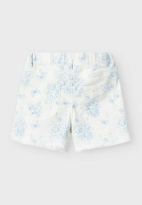 Vita denimshorts med ett ljusblått blommönster och fjärilar, med bakfickor och fransad fåll.