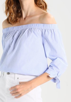 Blusa azul claro sin hombros con rayas blancas, escote fruncido y mangas tres cuartos, con detalles de lazos en los puños.