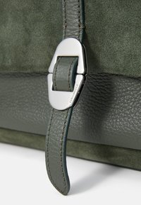Borsa a tracolla in pelle verde con texture scamosciata, caratterizzata da una fibbia in argento lucido e una tracolla in pelle coordinata, che mette in risalto un design a doppio materiale.
