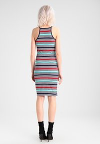 Strapless, aansluitende midi-jurk met meerkleurige verticale strepen in rood, blauw en turquoise. Gemaakt van rekbaar materiaal. Achteraanzicht.