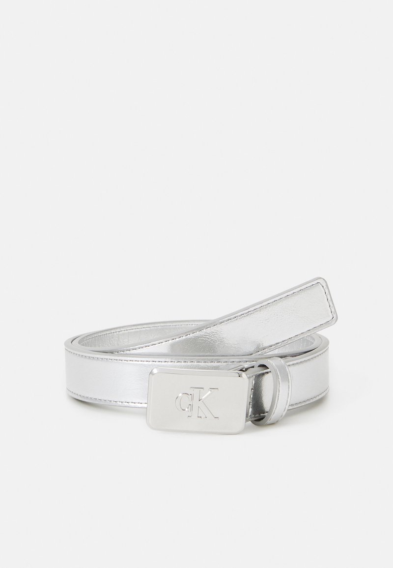Ceinture en cuir argenté avec une finition brillante, dotée d'une boucle en métal rectangulaire gravée de "CK". Le design est lisse et élégant.
