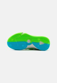 Talpă de pantof de atletism din cauciuc, cu o secțiune superioară verde și o secțiune inferioară albastră. Designul include un model de fălci în zigzag și accente circulare.