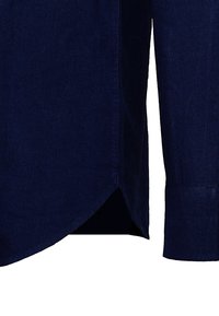 Námornícky modrá košeľa s dlhým rukávom a bočným lemom s zakriveným strihom a viditeľným šitím na látke.