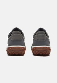 Zapatillas deportivas grises de material de gamuza y malla, con suela de goma marrón y un talón acolchado para mayor comodidad.