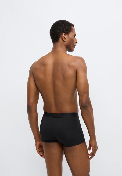 Juodi bokso šortai iš elastingos medžiagos, vientisos spalvos, su elastine juosmens juosta ir aptemptu prigludimu, matomi iš nugaros.