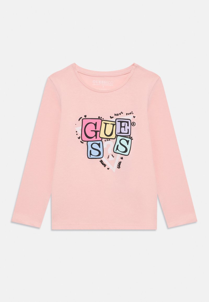 Różowa bluzka z długim rękawem z kolorową grafiką przedstawiającą słowo "GUESS" oraz zabawnymi akcentami, wykonana z miękkiego materiału bawełnianego.