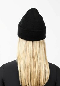 Black knit beanie with a tapered top and folded brim, displayed from the back with long blonde hair visible beneath.
