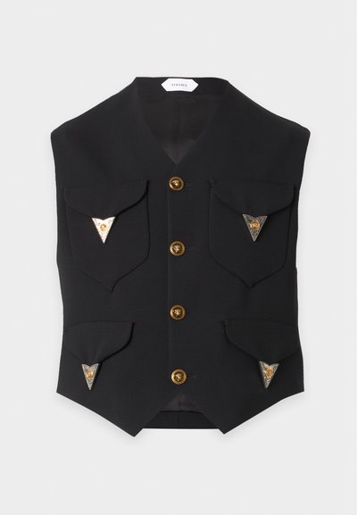 Gilet noir avec quatre boutons dorés et quatre poches à rabat, chacune décorée de détails métalliques triangulaires avec un emblème doré.
