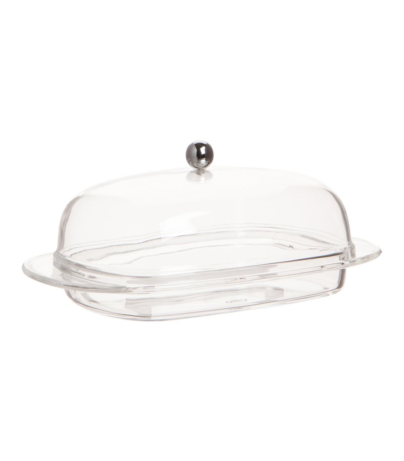 Przezroczysta szklana misa na masło z zaokrągloną kopułą, wyposażona w metalowy uchwyt na górze oraz płaską podstawę dla stabilności. Gładka faktura powierzchni.