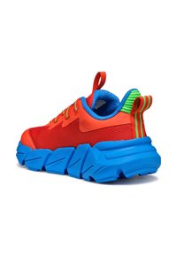 Zapatilla de malla roja con suela de goma azul, lengüeta en el talón a rayas verdes y rojas, cordones multicolores y cuello acolchado azul para mayor comodidad.