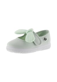 Zapato de lona verde claro con suela blanca y un lazo a rayas en la parte superior. Cuenta con una correa de Velcro y un diseño de punta redondeada.