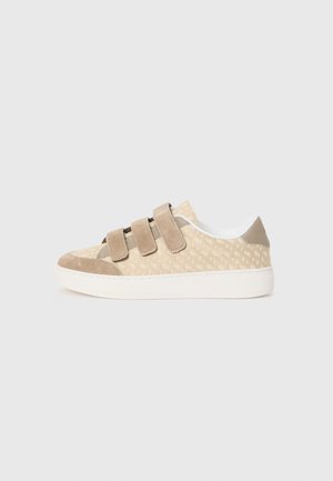 Beige sneaker with suede and textile upper, featuring three adjustable velcro straps, a white rubber sole, and a textured surface pattern.