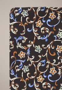 Czarna tkanina z wzorem kwiatowym w niebieskie, brązowe, zielone i pomarańczowe detale. Wijące się pnącza i kwiaty są wyraźnie widoczne w całej kompozycji.
