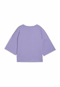T-shirt oversize lilla con colletto rotondo e maniche larghe lunghe fino ai gomiti. Tessuto morbido e design semplice senza dettagli aggiuntivi.
