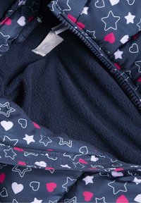 Chaqueta de forro polar azul marino con cremallera, decorada con estrellas y patrones de corazones en blanco y rosa.