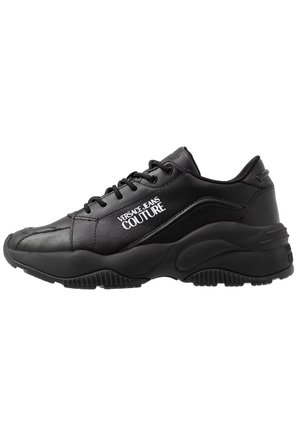 Sneaker nera Versace Jeans Couture con chiusura frontale con lacci e suola spessa, con logo bianco del marchio visibile sul lato.