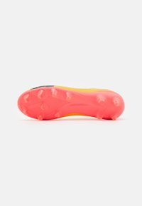 Suola di scarpini da calcio gialla con tacchetti in gomma texturizzata rosa. Presenta un design snello con una finitura liscia e dettagli di branding sottili.