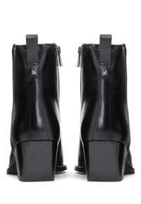 Black leather ankle boots with a shiny finish, square heel, and side zippers; features rectangular pull tabs and metallic accents.