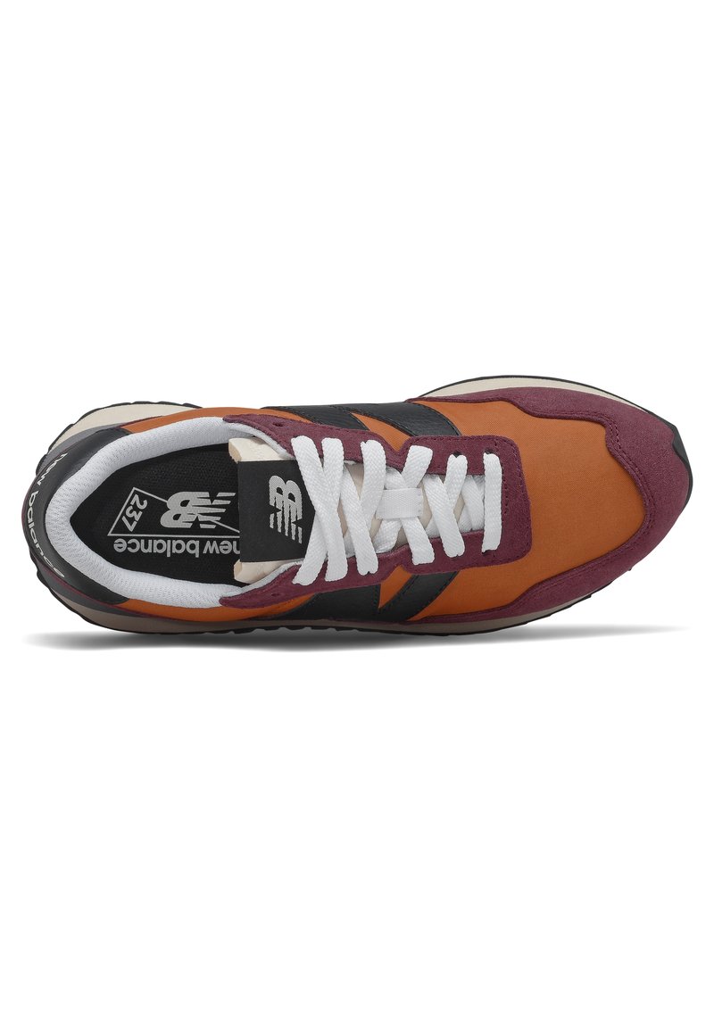 Zapatilla de running para hombres en ante naranja y burdeos con acentos en negro; cuenta con cordones blancos, una lengüeta acolchada y una suela de goma texturizada.