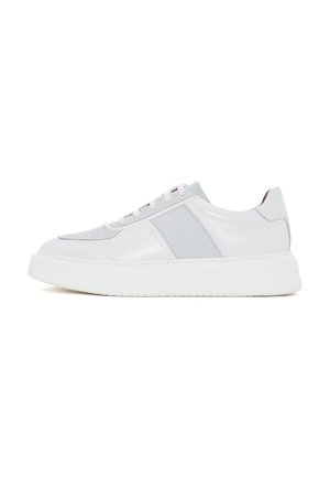 White leather sneaker with gray accents, rounded toe, flat lace-up design, thick white sole, and smooth texture. Minimalistic style.