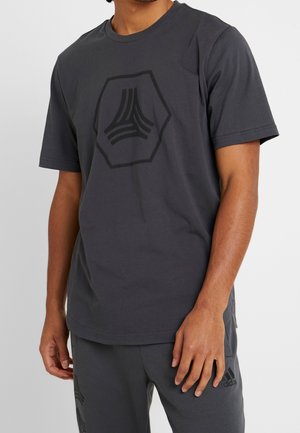 Dunkelgraues Baumwoll-T-Shirt mit kurzen Ärmeln, das auf der Vorderseite ein großes schwarzes sechseckiges Logo zeigt. Schlichter Rundhalsausschnitt und lässige Passform.