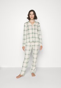Zweiteiliges Pyjama-Set aus Karostoff in weichem Material, bestehend aus einem Hemd mit Knöpfen, Kragen und langen Ärmeln sowie passenden Hosen mit elastischem Bund.