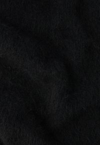 Czarna tkanina filcowa o miękkiej, teksturowanej powierzchni. Włókna wydają się puszyste i luźno utkane, tworząc ciepły i gęsty wygląd.