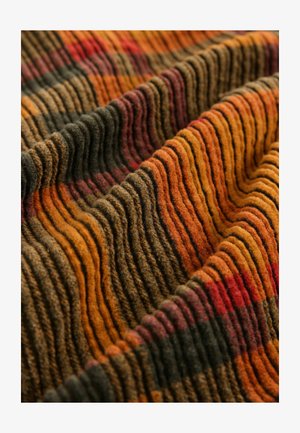 Tissu texturé dans des tons chauds d'orange, de rouge et de vert, présentant des rayures ondulées alternées avec des motifs distincts et une texture douce et laineuse.