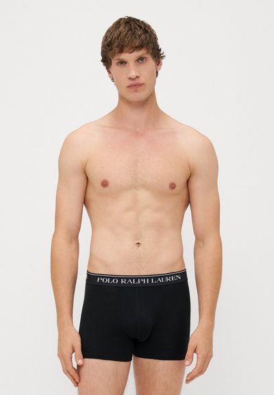Juodų medvilninių bokserių apatiniai su elastinga juosta, ant kurios užrašyta "POLO RALPH LAUREN" baltomis raidėmis. Modelis be marškinėlių.