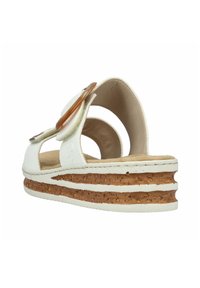 Sandales à plateforme blanches avec un intercalaire en liège, présentant un dos ouvert et des accents en tissu décoratifs. Texture lisse avec des bords arrondis.