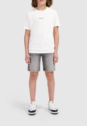 Witte katoenen t-shirt met zwarte "BALLIN" opdruk, gecombineerd met grijze denim shorts en witte sneakers met zwarte accenten. Casual outfitontwerp.