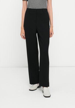 Pantaloni neri su misura con design a gamba dritta, dotati di passanti per cintura e una texture liscia. Abbinate a scarpe grigio chiaro.