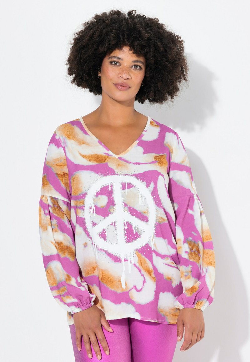 Top a manica lunga con scollo a V e grafica con simbolo della pace, caratterizzato da un motivo astratto nei colori rosa, bianco e arancione. Tessuto morbido con maniche a palloncino.
